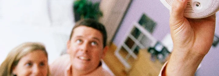 Person hält Rauchmelder hoch